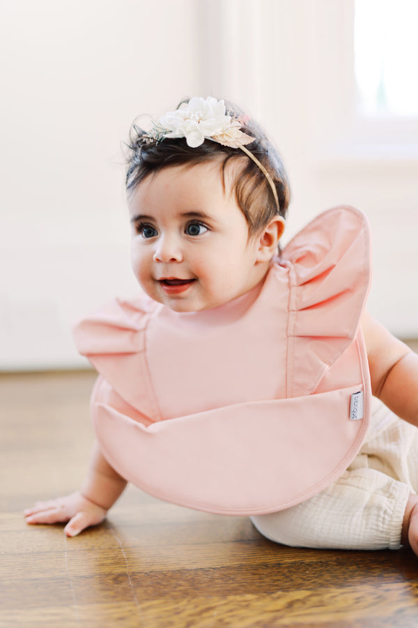baby infant girl wearing light pink blush ruffle angel bib by bibtique