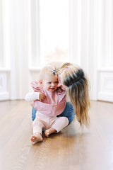 mom with baby girl wearing a ruffle baby bib