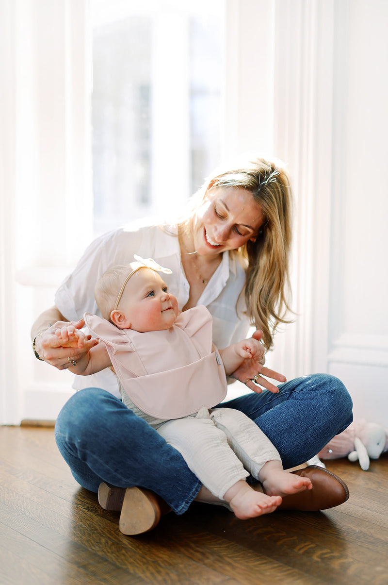 mom with baby wearing a ruffle angel bib 